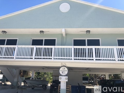 A white building with a balcony and a sign that says "Open".