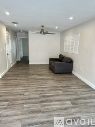 A living room with a couch and a fan.