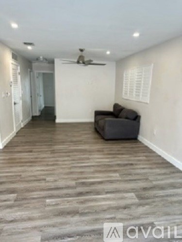 A living room with a couch and a fan.