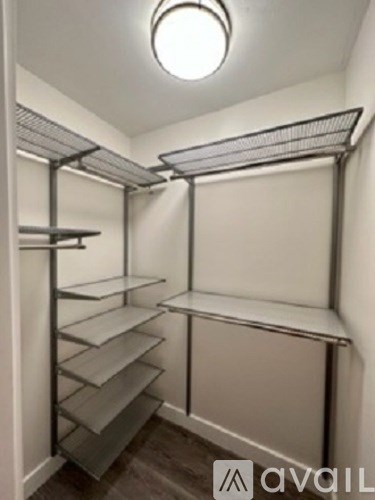 A walk-in closet with shelves and a hanging rod.