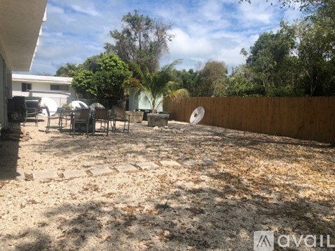 A backyard with a wooden fence and a satellite dish.