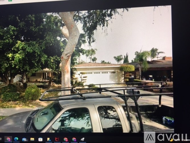 A car with a roof rack is parked in front of a house.