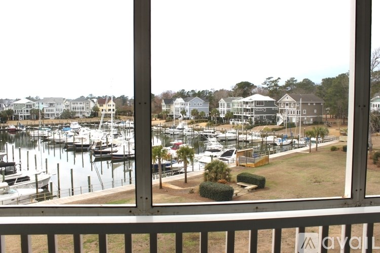 A marina with boats and houses in the background.