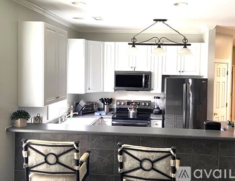 A kitchen with a black stove top oven and a black refrigerator.