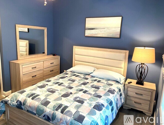 A bedroom with a bed, nightstand, and a mirror.