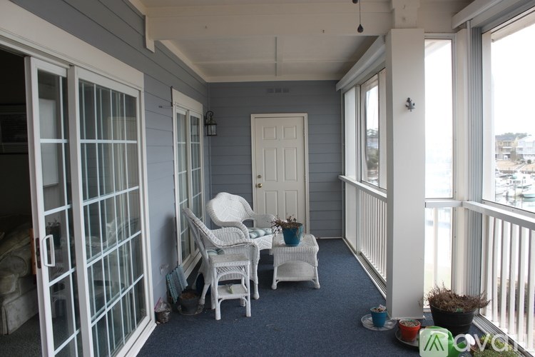 A balcony with a table and chairs overlooking the water.