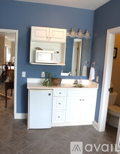 A bathroom with blue walls and a white vanity.