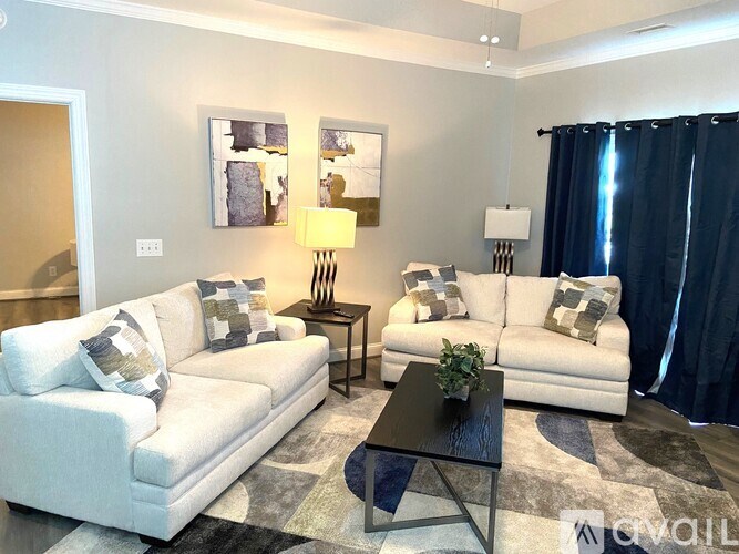 A living room with a white couch, a black coffee table, and a grey rug.