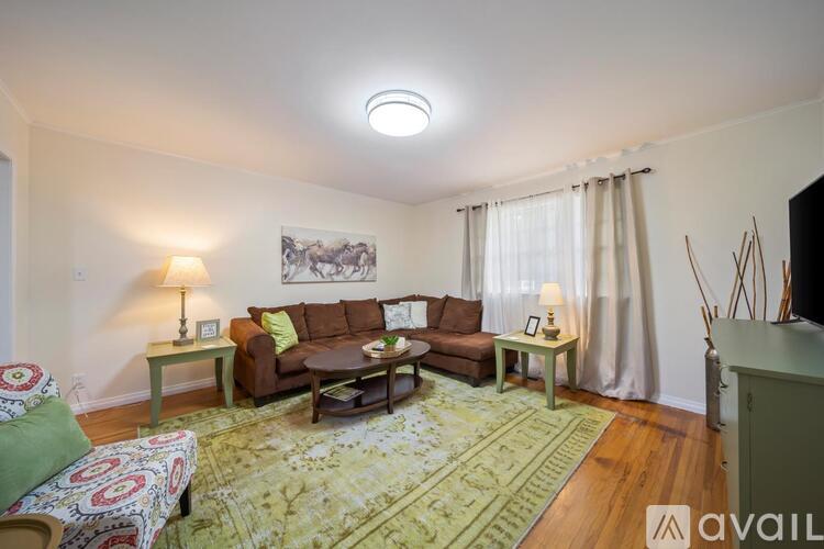A living room with a couch, a chair, a table, and a rug.