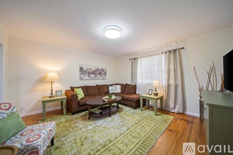 A living room with a couch, a chair, a table, and a rug.