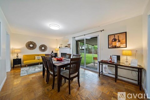 A dining room with a wooden table and chairs.