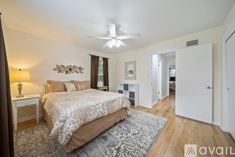 A bedroom with a large bed and a ceiling fan.