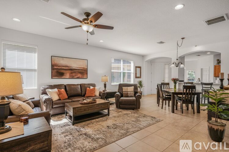 A living room with a brown couch, a coffee table, and a painting on the wall.