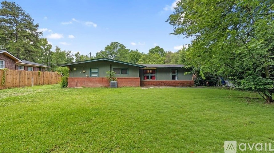 A house with a green lawn and a fence is available for sale.