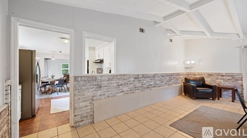 A living room with a couch and a stone wall.