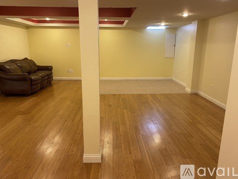 A living room with a brown couch and wooden floors.