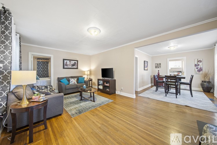 A living room with a grey couch and a wooden floor.