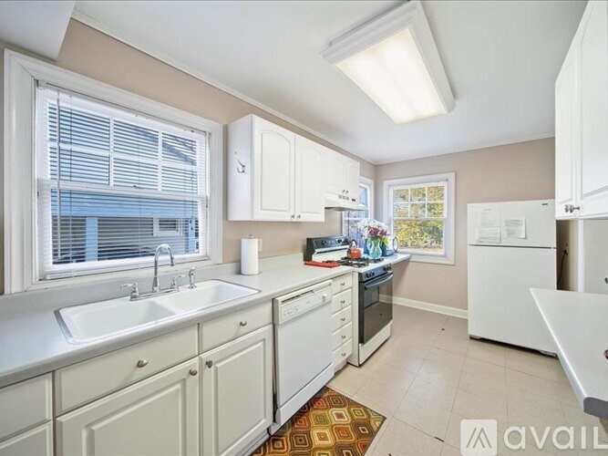 A kitchen with white appliances and cabinets.