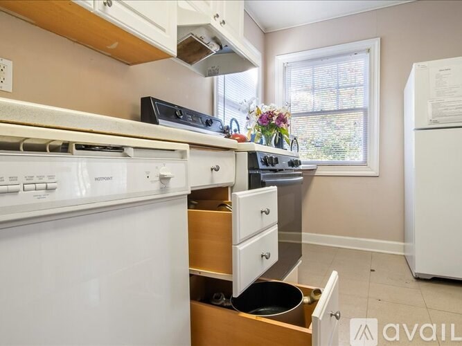 A kitchen with a white oven and a window with blinds.