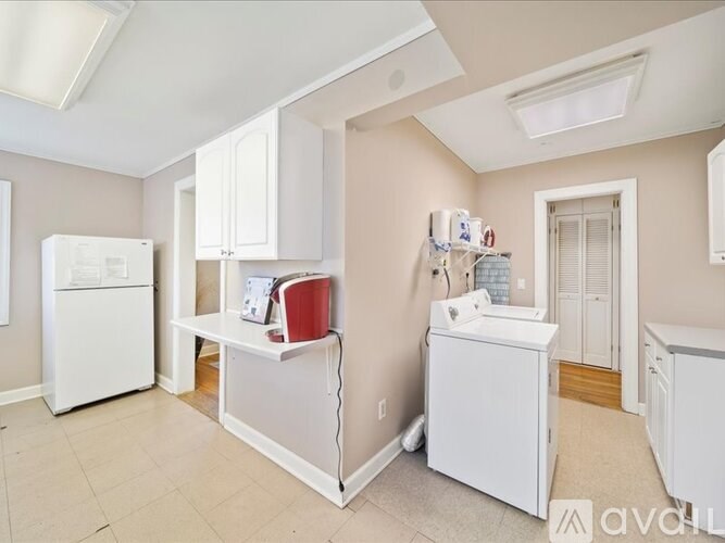 A kitchen with white appliances and cabinets.