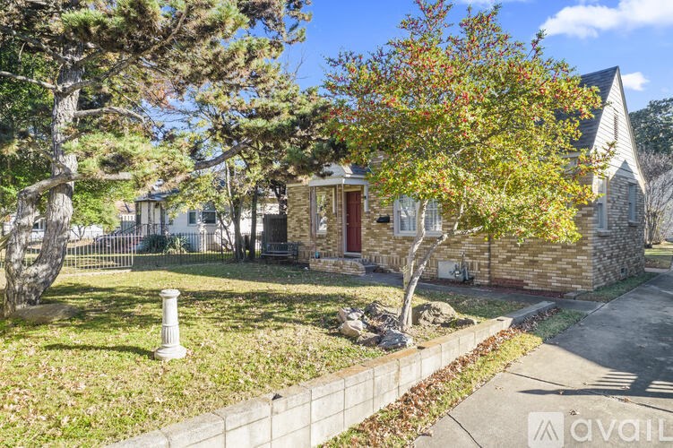A house with a red door is surrounded by trees and grass.