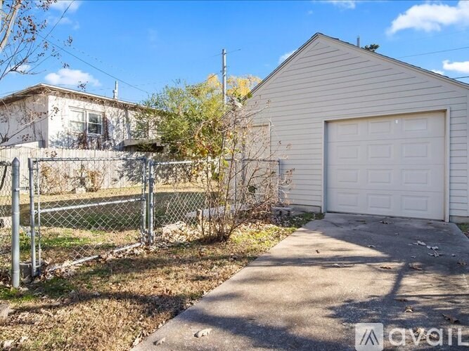 A white garage door is on the right side of a house.