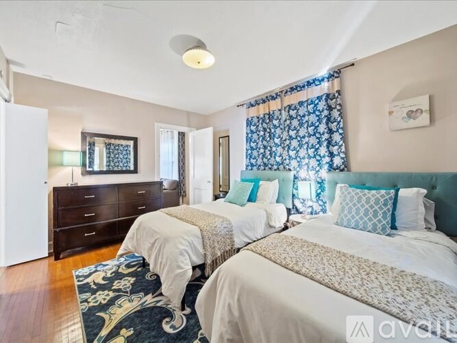 A bedroom with two beds and a dresser.