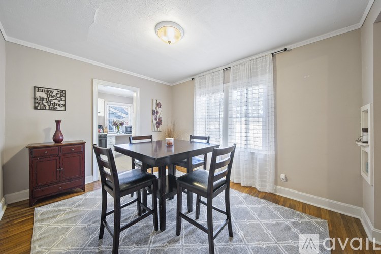 A dining room with a table and chairs.