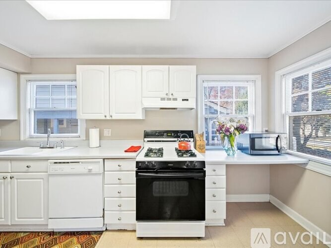 A kitchen with white appliances and cabinets.