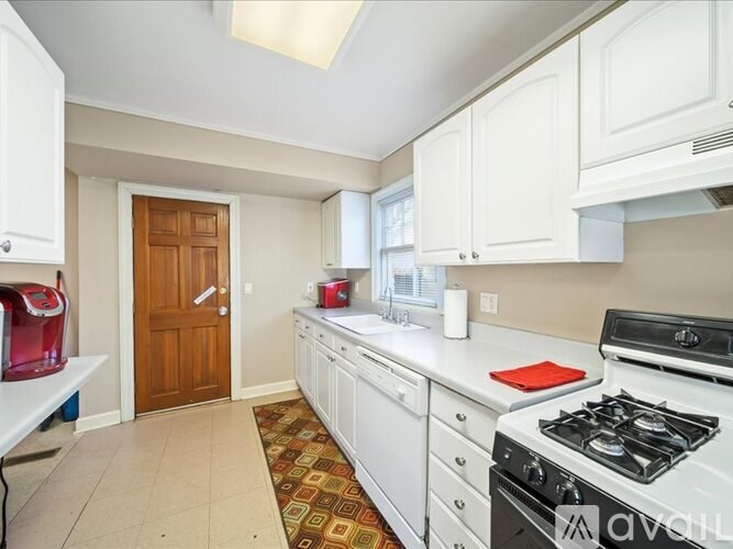 A kitchen with white cabinets and a white stove top oven.