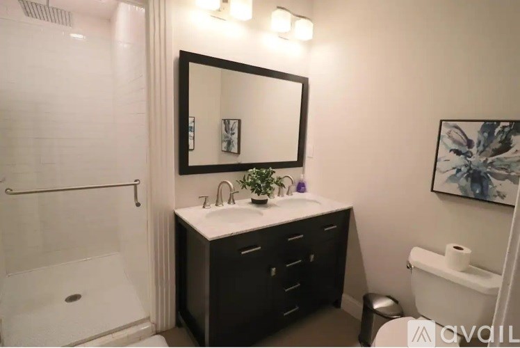 A bathroom with a sink, mirror, and toilet paper holder.