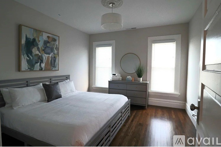 A bedroom with a large bed and a painting on the wall.