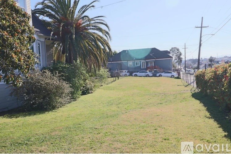 A house with a green lawn and a palm tree in front.