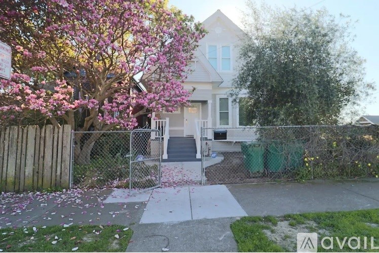 A house with a tree in bloom in front of it.