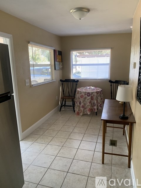 A kitchen with a table and chairs by the window.
