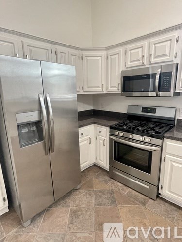 A kitchen with a stainless steel refrigerator and oven.