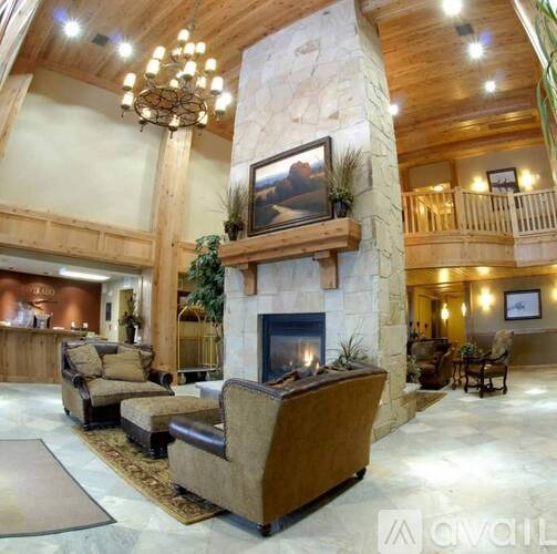 A large stone fireplace with a painting above it in a spacious room.