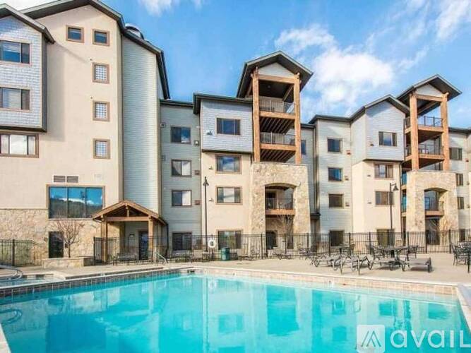 A large apartment complex with a pool in front.