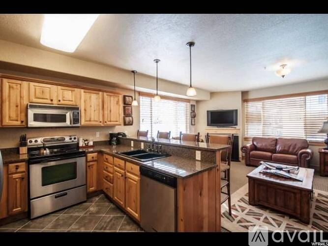 A kitchen with wooden cabinets and a black stove top oven.