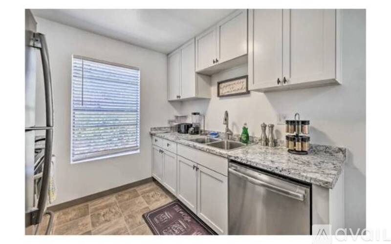 A kitchen with white cabinets and a granite countertop.