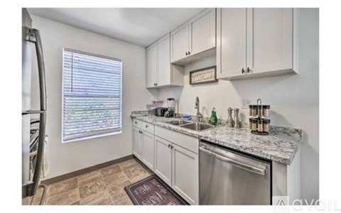 A kitchen with white cabinets and a granite countertop.