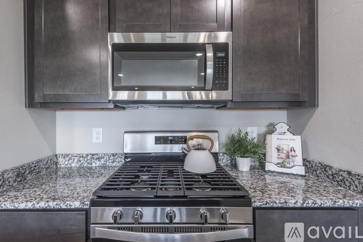 A modern kitchen with a stainless steel oven and microwave above it.