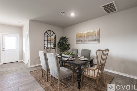 A dining room with a table set for four and a plant on the table.