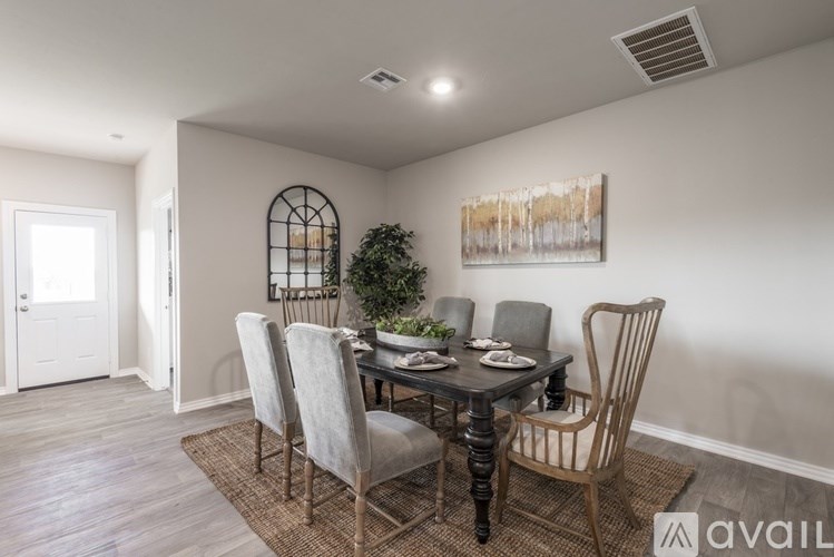 A dining room with a table set for four and a plant on the table.