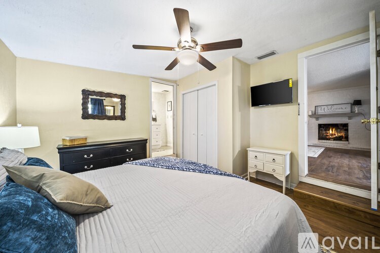 A bedroom with a bed, dresser, and a ceiling fan.