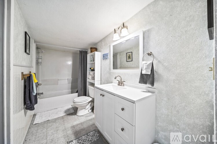 A bathroom with a white sink and toilet.