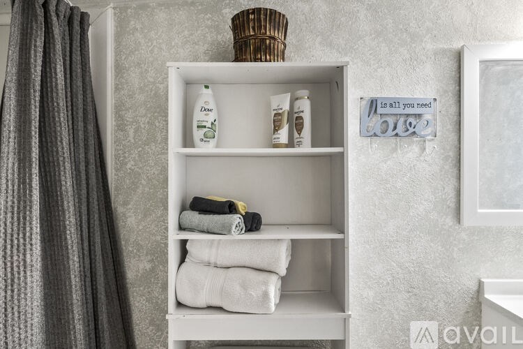 A bathroom shelf with toiletries and a sign that says "is all you need love".