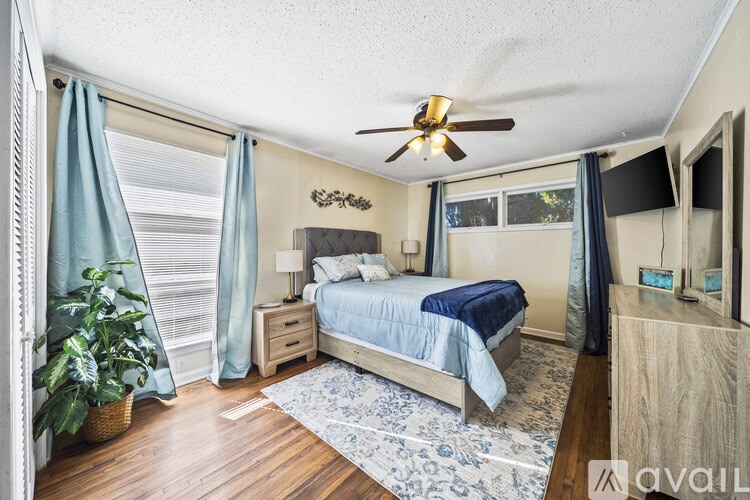 A bedroom with a bed, nightstand, and a ceiling fan.