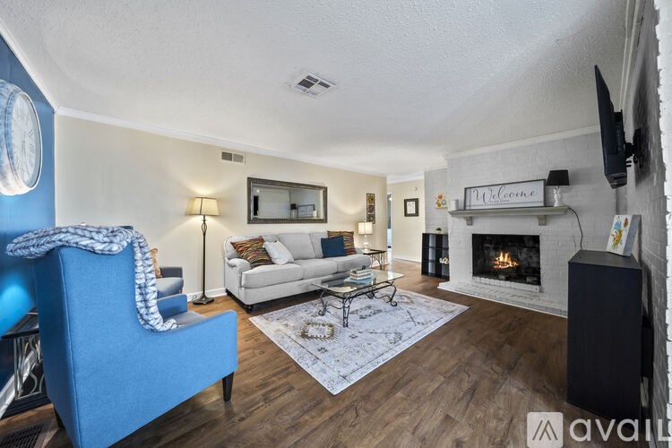 A living room with a blue chair and a fireplace.
