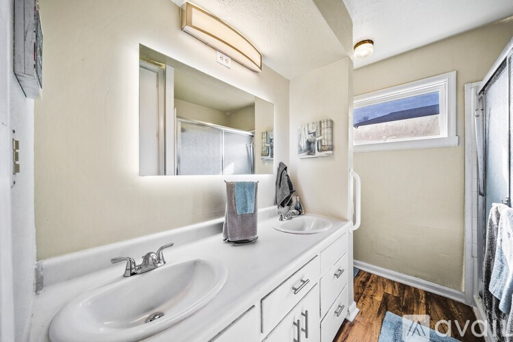 A bathroom with a white sink and a mirror above it.